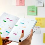 Person holding an open planner filled with notes and appointments
