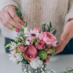 Person holding a small bouquet of pink and white flowers as a simple way to refresh a home space.