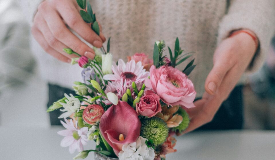 Person holding a small bouquet of pink and white flowers as a simple way to refresh a home space.