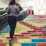 Woman jogging up outdoor stairs during a walk, showing simple everyday movement as part of realistic self-care.