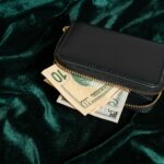 Wallet with cash partially visible on green velvet