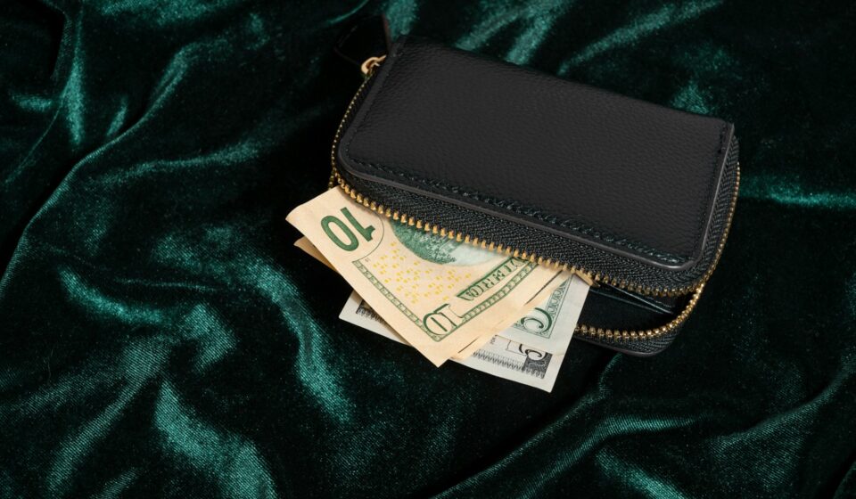 Wallet with cash partially visible on green velvet