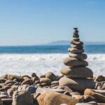 Stacked stones on a quiet shoreline, symbolizing balance and steadiness in everyday life