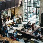Groups of people seated closely together eating and talking in a busy restaurant
