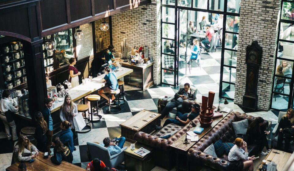 Groups of people seated closely together eating and talking in a busy restaurant