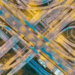 Aerial view of a complex highway intersection with multiple lanes and traffic flow at dusk