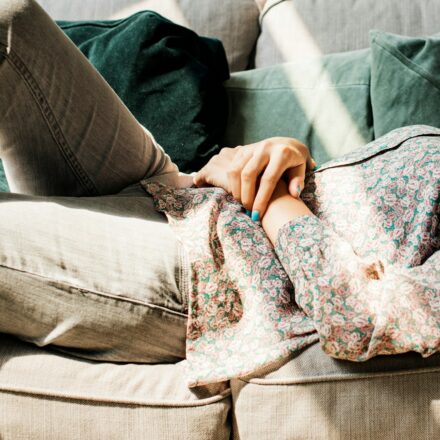 Woman lying on a couch looking tired and resting after a long day