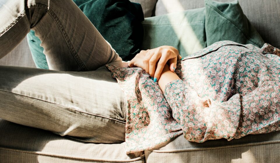 Woman lying on a couch looking tired and resting after a long day
