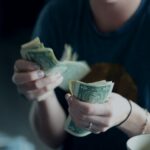 Hands counting cash in a quiet moment, representing everyday financial decisions and stress