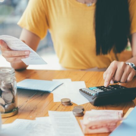 Person organizing cash and calculating expenses, representing small steps to manage financial stress