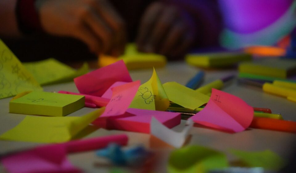 Surface covered with many colorful sticky notes representing multiple tasks and competing thoughts