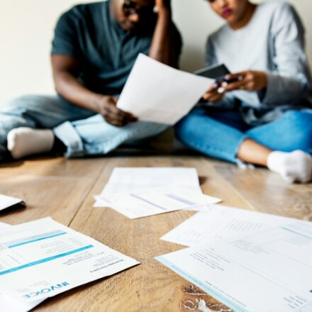 Couple sitting together reviewing finances at home, representing shared financial stress and overwhelm