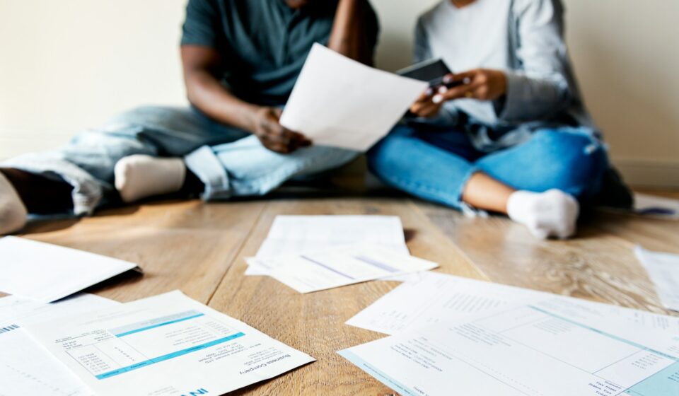 Couple sitting together reviewing finances at home, representing shared financial stress and overwhelm