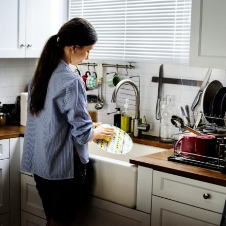Woman washing dishes in a kitchen after a meal