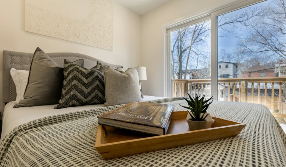 Cozy bed with a tray holding books in a calm and comfortable bedroom