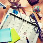 Planner and calendar pages with notes and reminders, representing competing priorities and scattered thoughts throughout the day.