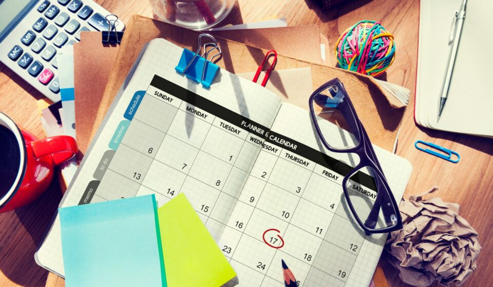 Planner and calendar pages with notes and reminders, representing competing priorities and scattered thoughts throughout the day.